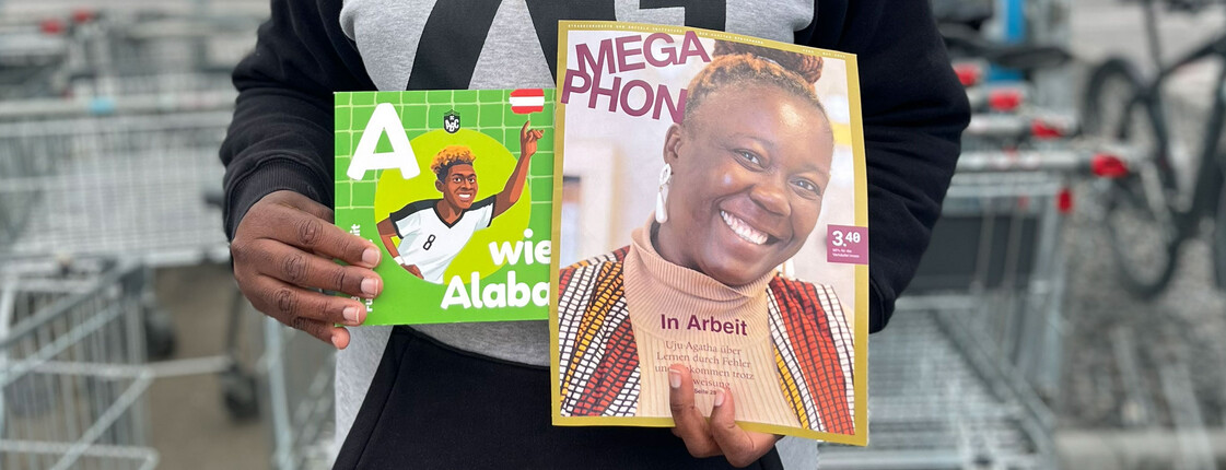 Eine Megaphon Verkäuferin mit dem neuen Megaphon Kinderbuch zur Fußball-WM