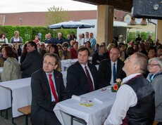 Viele Menschen sitzen an Tischen oder stehen