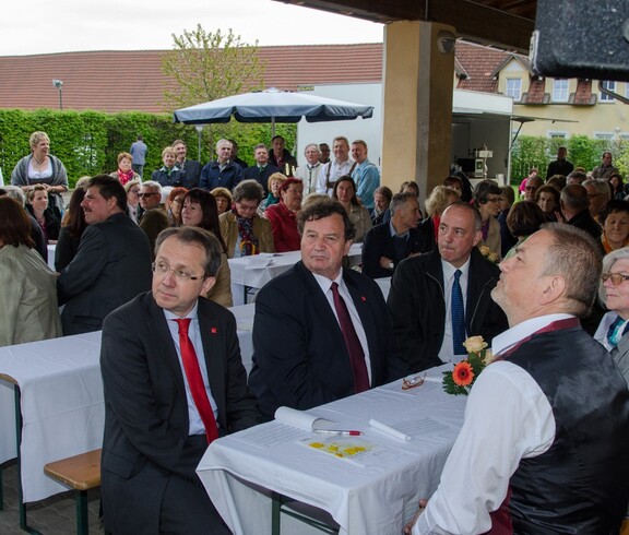 Viele Menschen sitzen an Tischen oder stehen