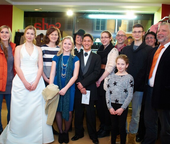 Mehrere Personen posieren lächelnd im carla Shop Amstetten.