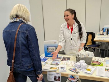 Zwei Frauen unterhalten sich an einem Informationstisch