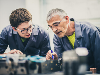 Senior engineer explaining machine functioning to his student