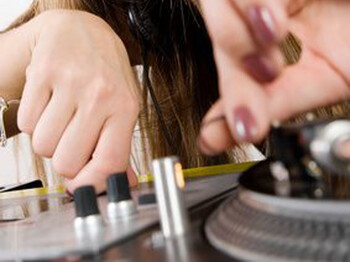 Eine Nahaufnahme der Hände eines Discjockeys, der gerade bei der Arbeit ist. 