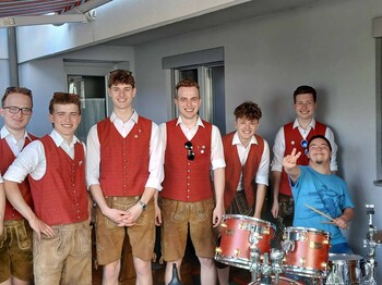 Mann mit einer Gruppe von Blasmusikern in Tracht