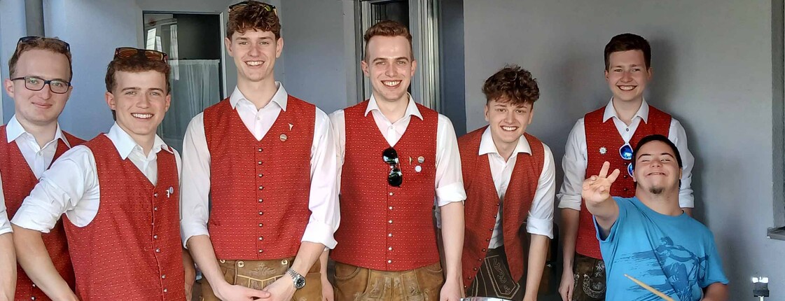 Mann mit einer Gruppe von Blasmusikern in Tracht