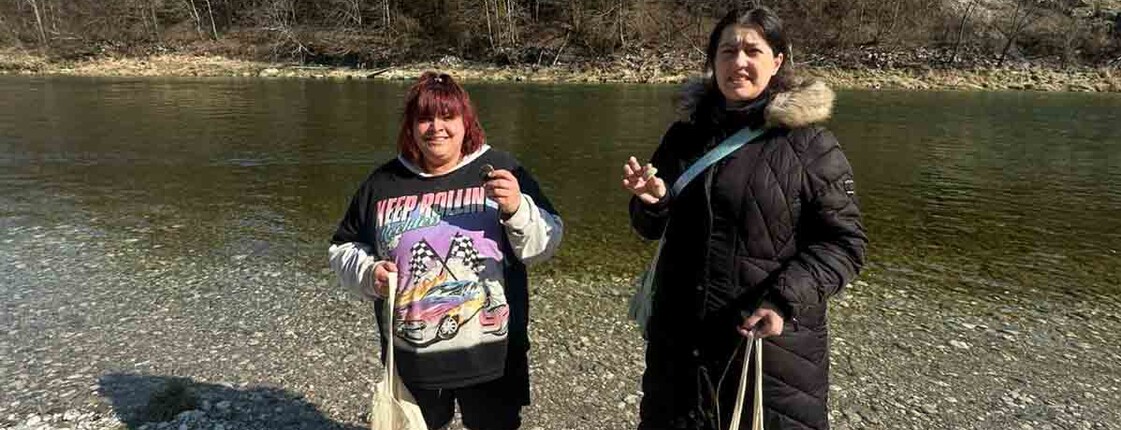 Zwei Frauen halten Flusssteine in der Hand.