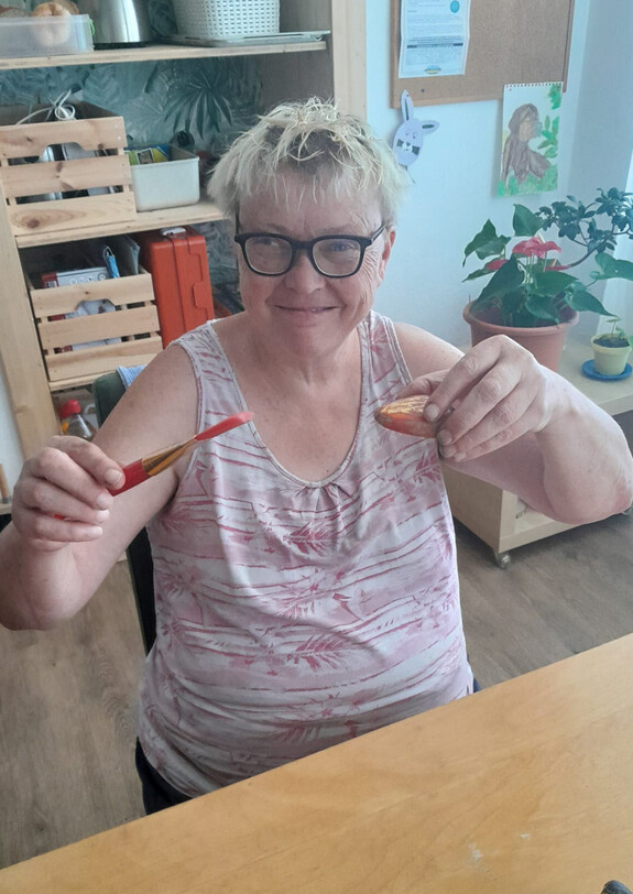 Stolz zeigt die Künstlerin ihren bemalten Stein her 