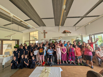 Gruppenfoto von Klient*innen, Gästen und Unterstützer*innen beim Sommerfest der Werkstatt Florian.
