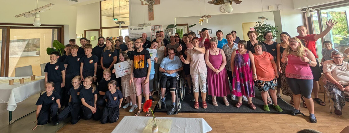 Gruppenfoto von Klient*innen, Gästen und Unterstützer*innen beim Sommerfest der Werkstatt Florian.