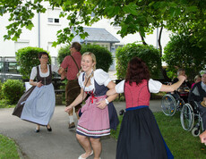 Sommerfest Haus St. Elisabeth tanzende Personen in Dirndl und Lerderhose
