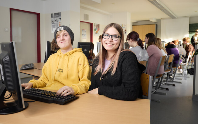 eine Schülerin und ein Schüler im EDV Unterricht