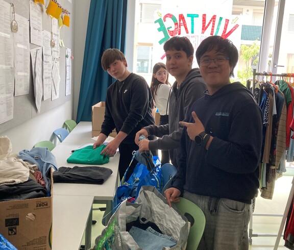 Schüler sortieren Kleidung für Vintage Kleidermarkt
