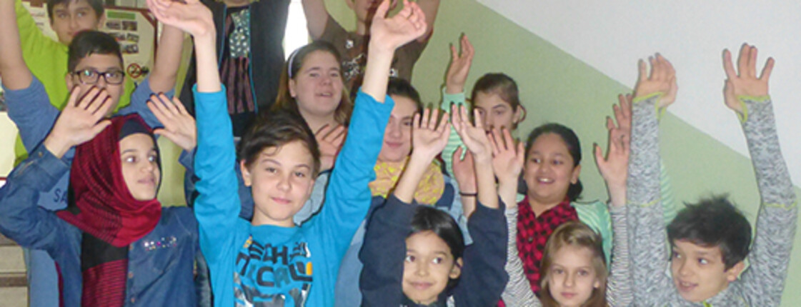 Schüler der NMS Neudörfl halten die Arme hoch und sehen in die Kamera