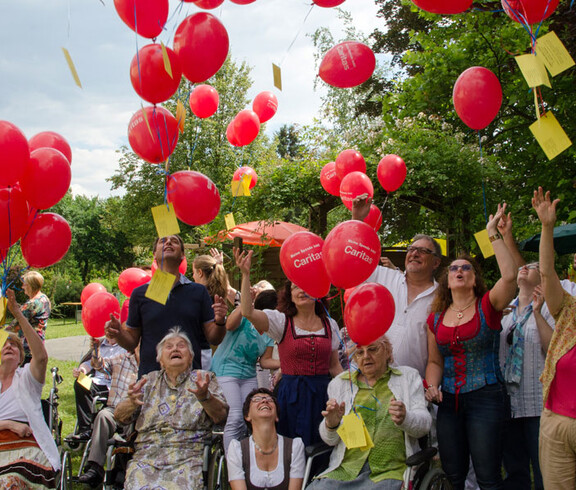Sommerfest Haus St. Elisabeth Gruppenfoto, wo sie rote Ballons steigen lassen