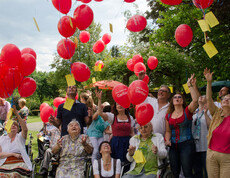 Sommerfest Haus St. Elisabeth Gruppenfoto, wo sie rote Ballons steigen lassen