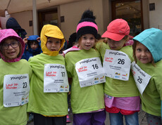 Vier Mädchen in Volksschulalter stehen zu einem Gruppenfoto zusammen. Sie tragen alle grüne Pullover. und unterschiedliche Kopfbedeckungen. Auch haben sie Startnummern auf ihrer Brust angeheftet. 