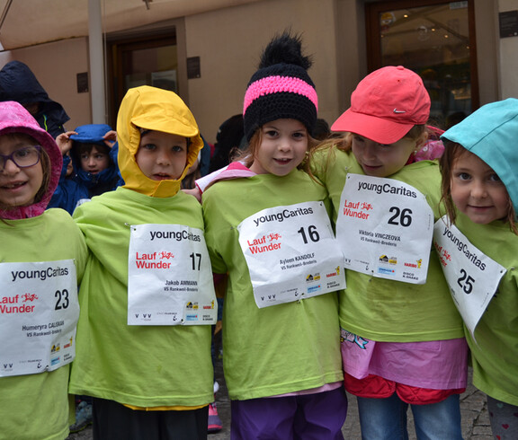 Vier Mädchen in Volksschulalter stehen zu einem Gruppenfoto zusammen. Sie tragen alle grüne Pullover. und unterschiedliche Kopfbedeckungen. Auch haben sie Startnummern auf ihrer Brust angeheftet. 