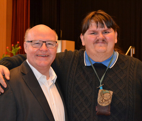 Caritasdirektor Peter Klinger mit Moderator Manni Schäfer. Bede sind schlicht in den Farben schwarz und weiß gekleidet. Sie wirken entspannt. 