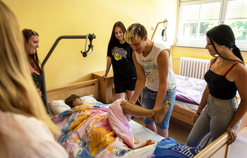 Ein Schüler der Schule für Sozialbetreuungsberufe mit dem Schwerpunkt Altenarbeit übt an einer Puppe das Verlagern an einem echten Patienten.
