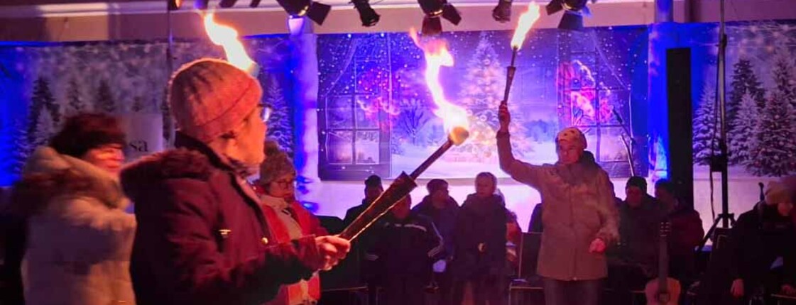 Mehrere Menschen jonglieren mit brennenden Fackeln.