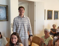 Ein Mann steht im Publikum. Der Rest sitzt.