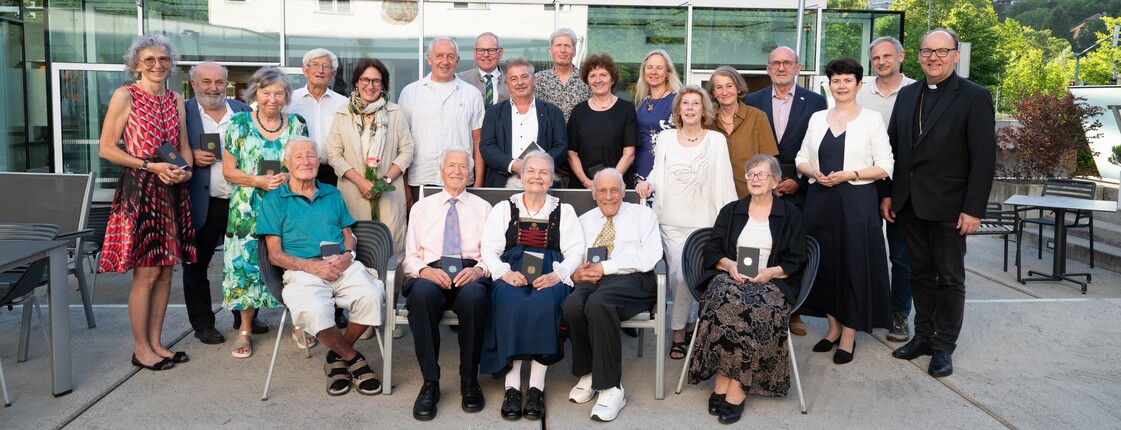 Gruppenfoto einer Gruppe Menschen vor einem modernen Gebäude.