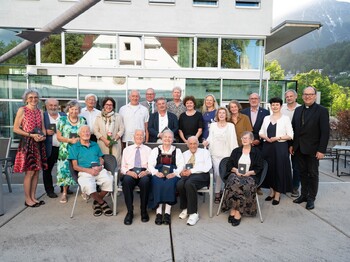 Gruppenfoto einer Gruppe Menschen vor einem modernen Gebäude.