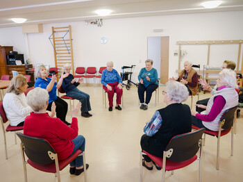 Ältere Menschen tanzen auf Seesel gemeinsam im Pflegewohnhaus.