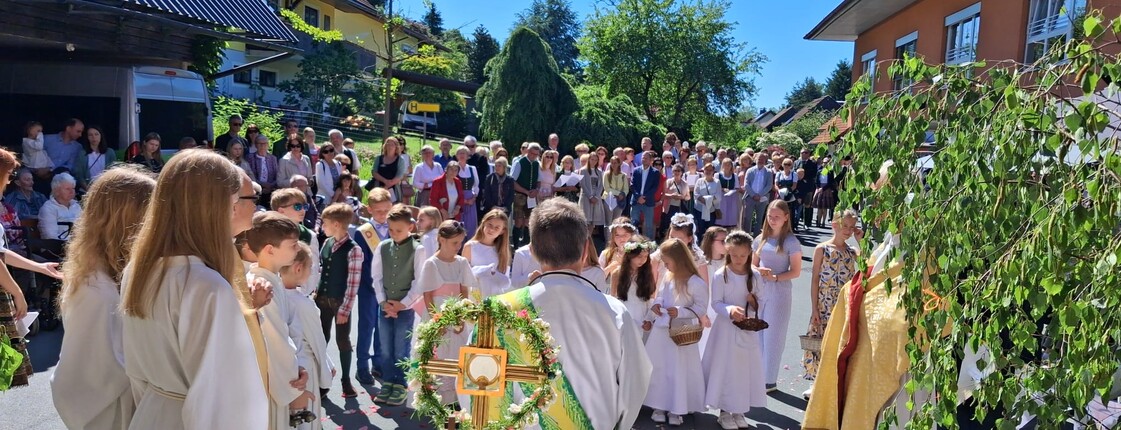 Vor dem Pflegewohnhaus versammelt sich eine große Prozession mit Kindern und Gottesdienstgestaltung, um gemeinsam eine feierliche Andacht im Freien zu feiern.