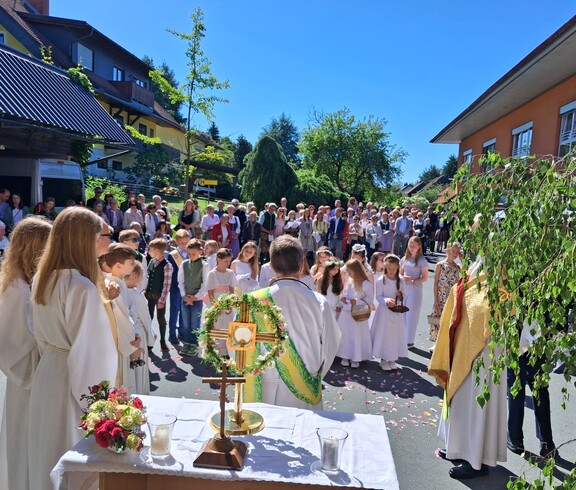 Vor dem Pflegewohnhaus versammelt sich eine große Prozession mit Kindern und Gottesdienstgestaltung, um gemeinsam eine feierliche Andacht im Freien zu feiern.