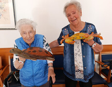 Zwei Bewohnerinnen halten fertig gestaltete Papiermaché-Figuren wie Schildkröte und Krabbe in den Händen.