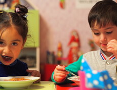 Zwei Kindergartenkinder essen eine warme Gemüsesuppe