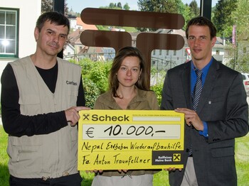 Spendenübergabe der Firma Traunfellner. Geschäftsführung übergibt Spendenscheck an Caritasmitarbeiter Andreas Zinggl.