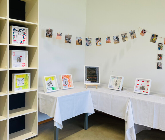 Gerahmte Kunstwerke und Fotos der Vernissage „Grenzenlos“ in der Werkstatt Florian.