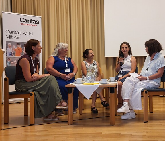 Fünf Frauen im Gespräch sitzend.