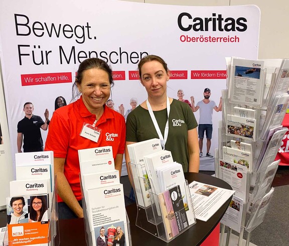 Zwei Frauen am Caritas Messestand mit vielfältigem Informationsangebot