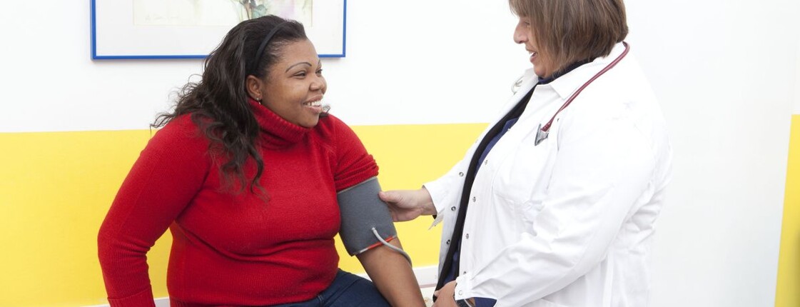 Eine Ärztin misst den Blutdruck einer Patientin.