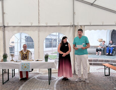 Andacht im Festzelt des Sommerfests im Haus Theresia mit Geistlichem und zwei Mitarbeitenden vor dem Altar.