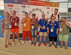 Mannschaft mit Medaillen in der Sporthalle