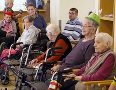 Acht ältere Bewohner hören Musik