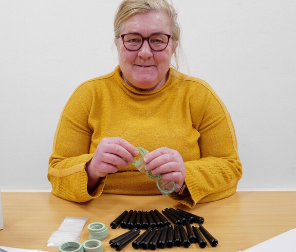 Frau in gelbem Pullover verpackt Montagematerial