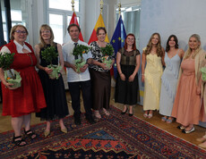 Gruppe von Erwachsenen mit Pflanzen in Händen vor Fahnen von Kärnten und EU