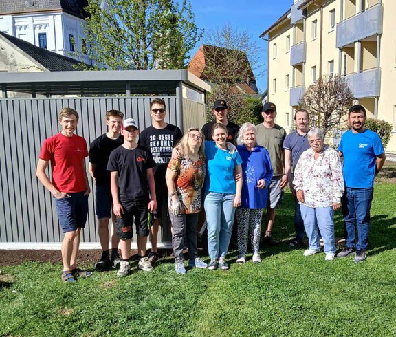 Viele Menschen vor einer Gartenhütte