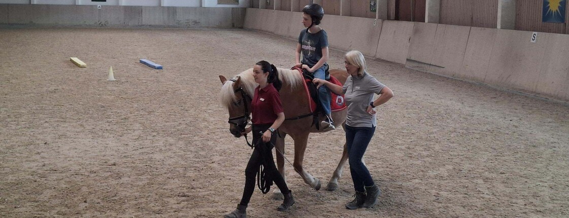 Pferd, Reiter und zwei Therapeuten