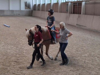 Pferd, Reiter und zwei Therapeuten