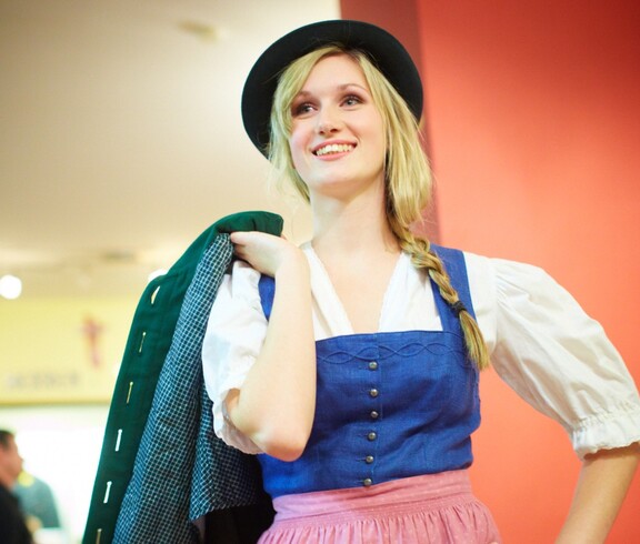 Eine Frau posiert lächelnd mit der Kleidung des carla Shops.