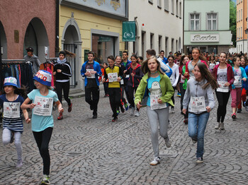 In der feldkircher Innenstadt wurde eine Laufveranstaltung. Etliche Kinder und Jugendliche springen in den Gassen herum. Sie haben auf der Brust jeweils ihre Laufnummer. 