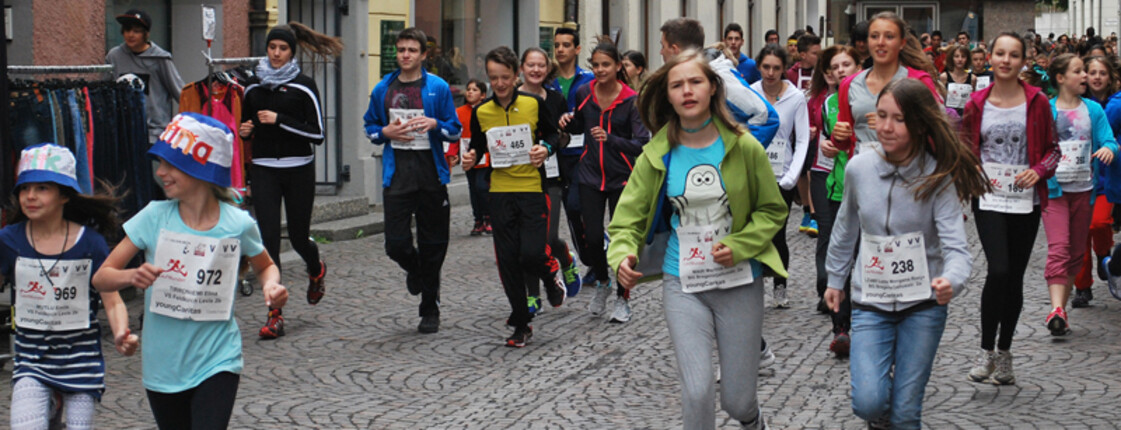 In der feldkircher Innenstadt wurde eine Laufveranstaltung. Etliche Kinder und Jugendliche springen in den Gassen herum. Sie haben auf der Brust jeweils ihre Laufnummer. 