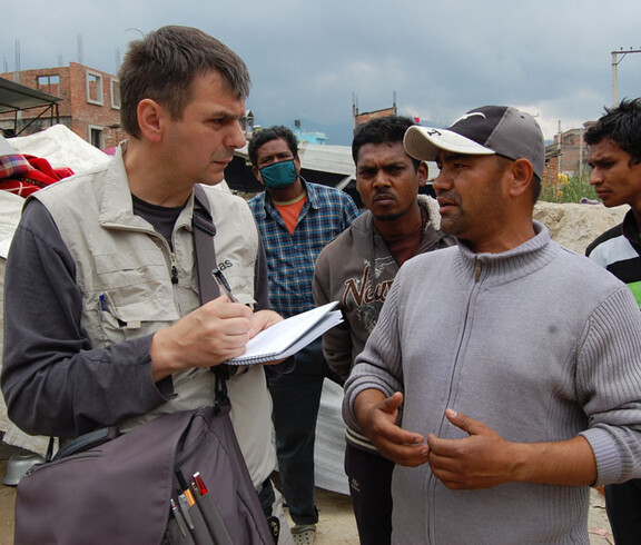 Caritas Helfer Andreas Zinggl unterhält sich in Kathmandu mit Einwohnern.