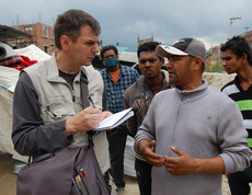 Caritas Helfer Andreas Zinggl unterhält sich in Kathmandu mit Einwohnern.
